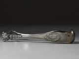 une cuillère en argent posée sur une table blanche, sur fond noir