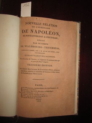 un livre ouvert sur une table, sur lequel est posé un étiquette