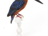 un oiseau assis sur un piédestal blanc