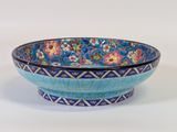 blue and pink bowl with floral designs on it on a white surface