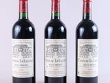 trois bouteilles de vin rouge posées côte à côte sur une table