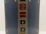 un vieux livre à la couverture bleue, rehaussée de dorures, sur un fond blanc