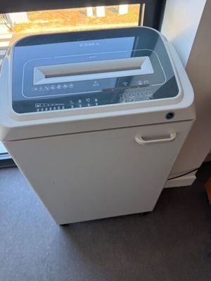 une photo d'une petite machine à laver devant une fenêtre