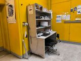 a small desk with a computer on it in a yellow room