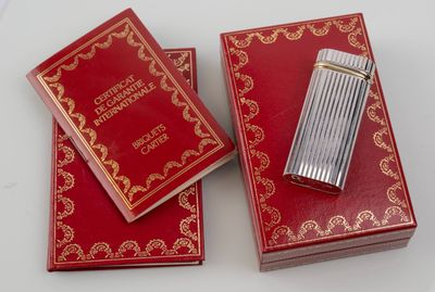 two red boxes with gold trimming and a lighter on top of them