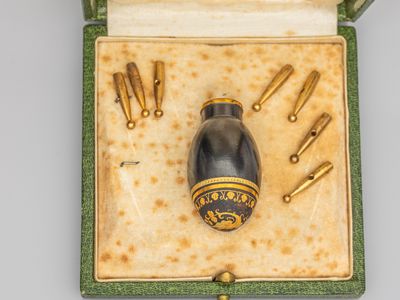 une petite boîte contenant un objet doré et noir