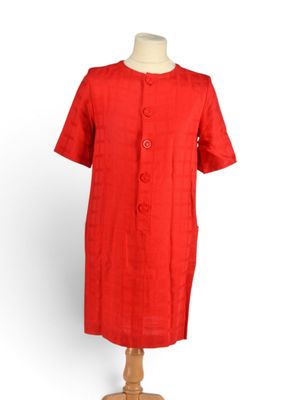 une robe rouge posée sur un pied de mannequin, sur fond blanc