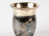 a black and gold vase sitting on a white surface
