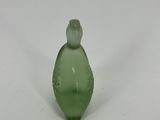 green glass figurine of a bird on a white surface