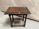 une petite table avec un plateau en bois sur un sol en ciment