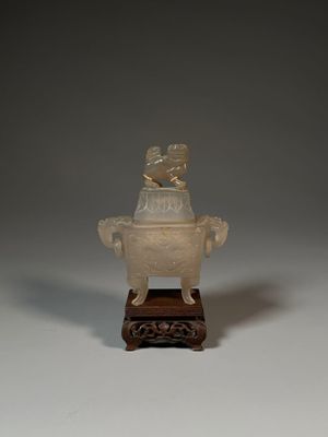un petit vase blanc surmonté d'un oiseau
