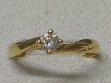 a diamond ring on a white surface with a gold band