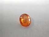 a close up of an orange diamond on a white surface