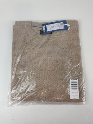 Le pull est emballé dans du plastique et prêt à être expédié.