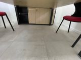 two red chairs sitting at a table in a room
