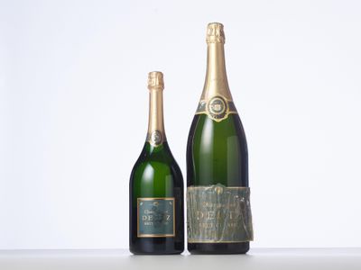 two bottles of champagne sitting next to each other on a table