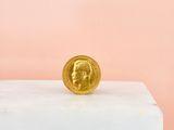 a gold coin sitting on top of a marble block