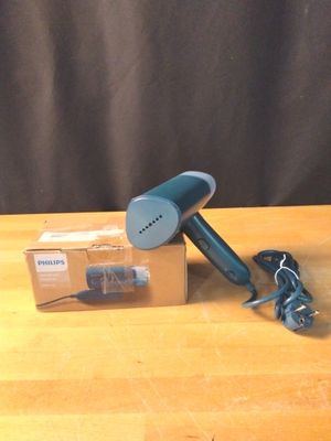 un sèche-cheveux bleu posé sur une table à côté d'une boîte