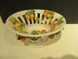 a white bowl with flowers on it sitting on a table