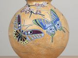 un vase orné d'un motif de papillon, posé sur une table