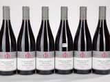 six bouteilles de vin rouge sont alignées