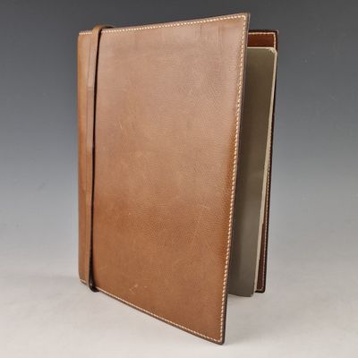 a brown leather journal with a white stitching on the cover