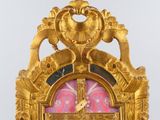 a gold clock with a pink and red pattern on it