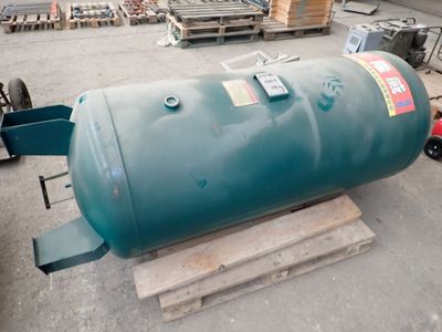 a large green tank sitting on a pallet in a warehouse