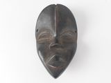 an image of a wooden mask hanging on a wall