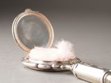 a small mirror with a pink floss on top of it