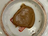 a white plate with a brown seal on it