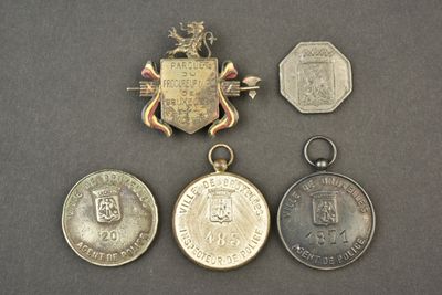 trois médailles et une médaille posées sur une table avec un fond noir