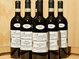 six bouteilles de vin sont alignées sur un tonneau
