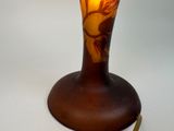 a glass vase with a bird on it on a table
