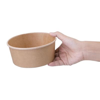 une personne tenant un bol en papier à la main