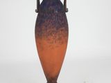 a blue and orange vase sitting on a white surface