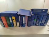 Plusieurs classeurs sont empilés les uns sur les autres sur un bureau