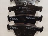 four brake pads on a white wall with the words bosch on them