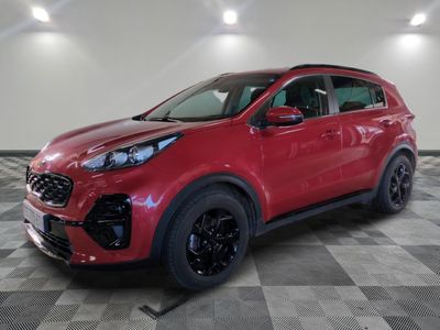 a red car is parked on a checkered floor in a garage