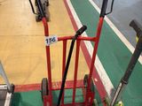 a red hand truck with a wheel on the side of the road