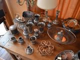 a wooden table with a lot of silver items on it