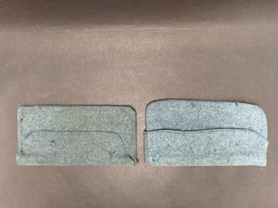 two pieces of felt sitting on top of a brown surface