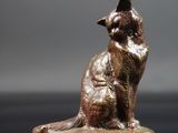 un gros plan sur la statue d'un chat assis sur une table