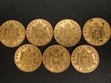 six gold sovereigns, one of which has a coat of arms on it