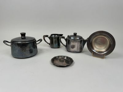 trois théières en métal argenté, une soucoupe et une assiette en argent