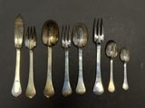 a lot of silver spoons and forks on a table