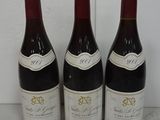 three bottles of wine are lined up on a counter
