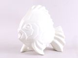 une figurine de poisson en céramique blanche posée sur une surface blanche