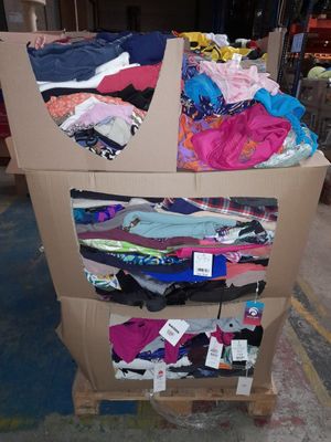 un chariot en carton sur lequel sont disposés de nombreux types de vêtements différents