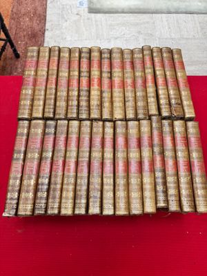 une pile de vieux livres posée sur une table rouge